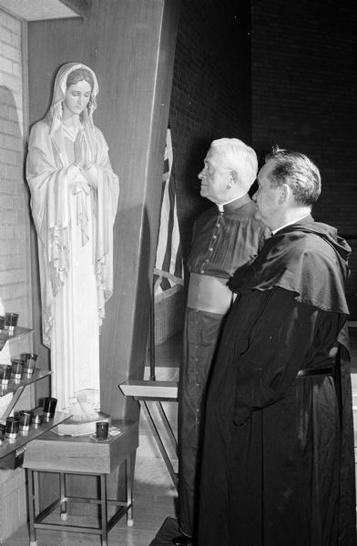 A special novena in honor of Our Sorrowful Mother was held at Our Lady Queen of Peace Catholic Church. Reverend C.M. Brissette of the National Shrine of Service Fathers in Chicago was the guest speaker at the first of nine novena services. Shown (left to right) before the shrine of Our Sorrowful Mother are: Msgr. F.L. McDonnell, pastor of the church, and Fr. Brissette.