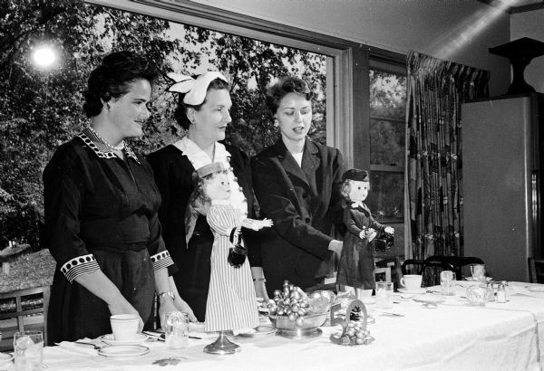 Group portrait of attendees of the annual meeting of the Madison Visiting Nurse Service at the Blackhawk Country Club. Members of the decorating committee for the meeting are shown with some of their handiwork, from left to right: Adriene L. Grannis, Marjorie A. Hagan, and Dorothy Lane.