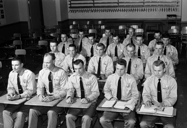 Nineteen new police recruits are shown sitting in class. The men who are in pre-service training began classes September 16 and will graduate in January.