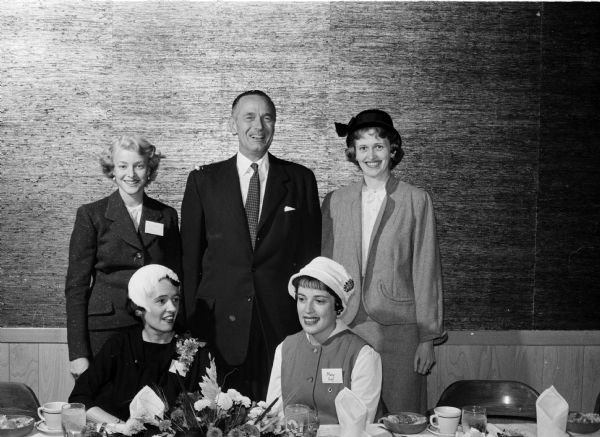 Five people posing for a group portrait at the dinner meeting of the Junior Chamber of Commerce auxiliary (Jaycettes). Sitting are: Jane Weikel and Mary Gay, president of the Jaycettes. Standing are: Mrs. Robert Lee, Don Anderson, publisher of the <i>Wisconsin State Journal</i> who was the speaker; and Mrs. William Sparks, membership chairman.