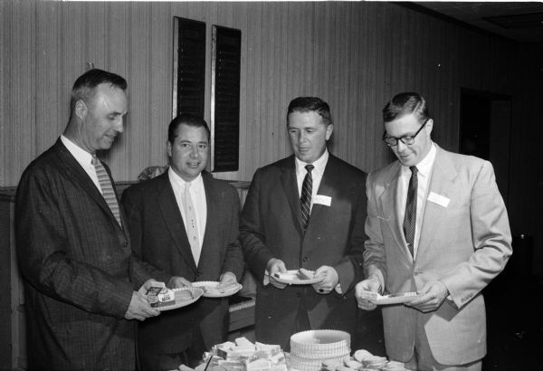 Principal Ralph Christofferson, left, helps himself to a smorgasbord at West High School's Alumni W Club along with three of his former students. Others, left to right, are: Jack Kessenich, 1942; Al Felly, 1942; and Jack Mansfield, 1952.