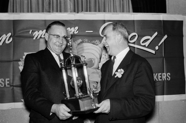 Ronald E. Johnson of Mt. Sterling in Crawford County, Wisconsin, was named the winner of the World Cheddar Cheese Championship at the Hotel Loraine. He receives the trophy from Governor-Elect Gaylord Nelson at the banquet of the Wisconsin Cheesemakers' Association.