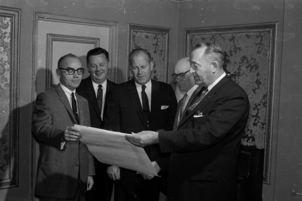 L.R. Musselman, president and general manager of the Madison division of the Kroger Co., is honored with an "Award of Special Merit" for his civic work in Madison. Shown inspecting the scroll are (left to right): R.A. Eissfeldt, Henry Behnke, L.R. Musselman, Marshall Browne, and I.W. Lackore.