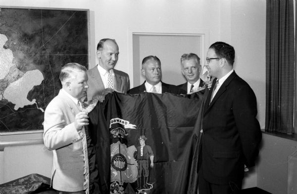 The city of Madison receives a state flag from the Safety Division of the State Motor Vehicle Department for its record in improving its traffic accident record. The flag was made available by the Allstate Insurance Company. Shown (left to right) are: Clifford Hawley, Madison Board of Education; Mayor Ivan A. Nestingen; Police Chief Bruce Weatherly; Melvin Larson, state motor vehicle commissioner; and Frank A. Rossi, Allstate Insurance Company representative.