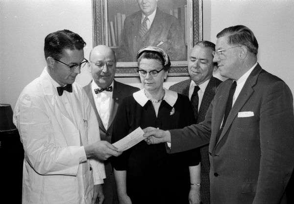 The Henry Schroeder Council of the Telephone Pioneers of America (TPA) presenting a check for $499.95 to Dr. Nathan Smith, professor of pediatrics at Wisconsin General Hospital. The money will be used in providing recreational facilities for children in the children's hospital. Shown (left to right) are Dr. Smith; R.J. Fischer, manager; Mrs. Olive Graham, assistant chief operator; Thomas Fiedler, district engineer; and Orville C. Hankwitz, installation supervisor.