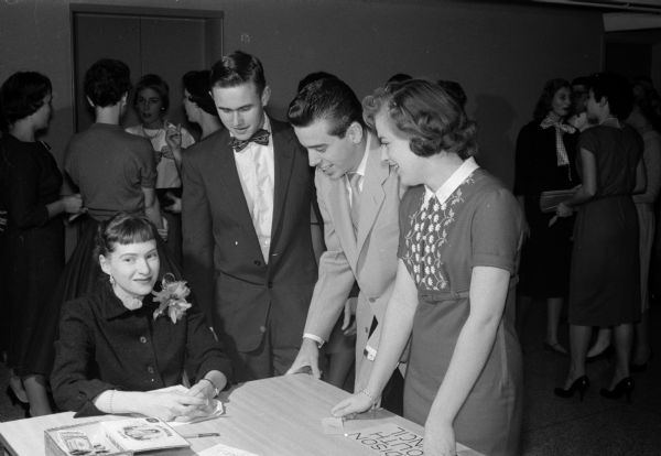 A group gathers around the registration desk for the 12th annual Madison Youth Council banquet in the Wisconsin Center. Shown (left to right) are: Mrs. Betsy Livingston, Bill Hales, Bill DuBois, and Donna Wagner.