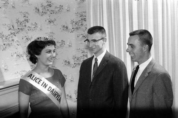 Barbara Haslow (left), Alice in Dairyland, is the guest of honor at the sixth annual Dairy Day of Alpha Gamma Rho fraternity. With her are fraternity members James Weyhmiller (center) and Paul Hartwig (right).