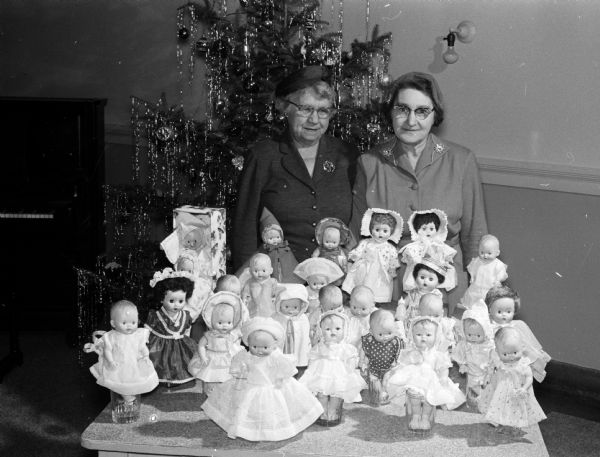 Mrs. O.H. (Lauraine) Jensen of 2317 East Mifflin Street, chairman of the Women's Club of Madison's orthopedic work, and Mrs. Gertrude Kepke, 2354 Commonwealth Avenue, chairman of the social service department, dress dolls for hospitalized patients at the Orthopedic Hospital.