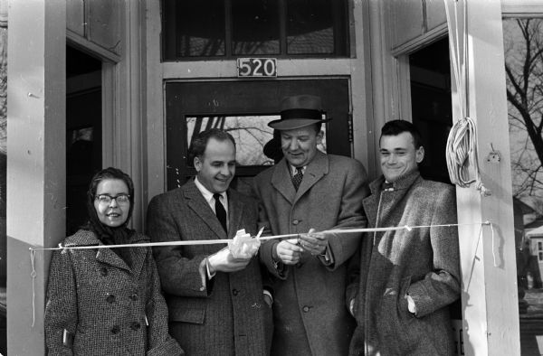 A group attends the ribbon-cutting ceremony for Madison's new store, operated by handicapped people. Gathered in the doorway are Hazel Vivian, 1954 East Washington Avenue, Governor Gaylord Nelson, Mayor Ivan Nestingen and Tom Parks, 600 Morningside Road. The new store is at 520 North Street.