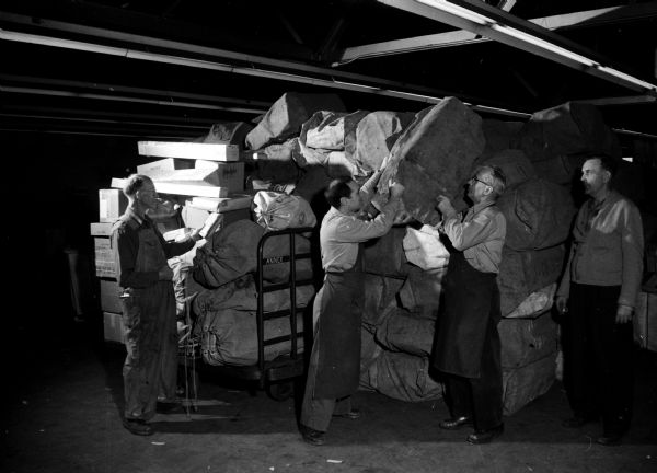 Postal workers deal with a shipment of Christmas mail that was "arriving by the roomful and the ton."  Workers are, left to right: William Borjinkhof, John Coliva Jr., Leonard Meyer, and C.F. Hunt, foreman.