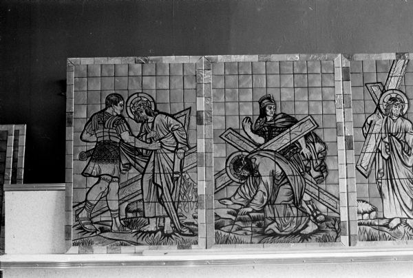 View of one of the 14 stations-of-the-cross glass mosaic panels recently installed at St. Patrick's Catholic Church in Janesville. In this panel, Christ is seen with his cross and a Roman soldier. The panels were manufactured by the Rath Church Decorating Service in Madison, which claims it to be the first use of glass mosaics in the United States.