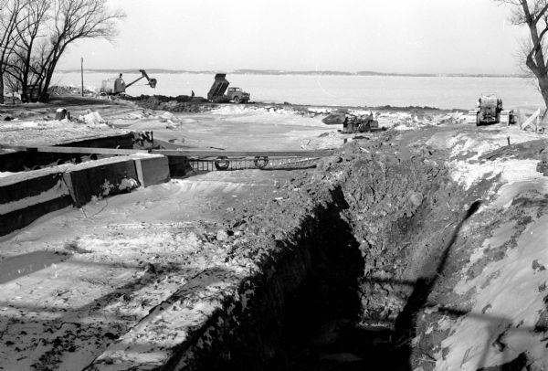 Work on the new Tenney Park lock and dam is progressing on schedule. A temporary spillway (not shown) has been built to divert the Yahara River from the construction site. The old lock can be seen in the left foreground and the old spillway to the right of the old lock. City Engineer John G. Thompson says that the project will be completed in mid-May.