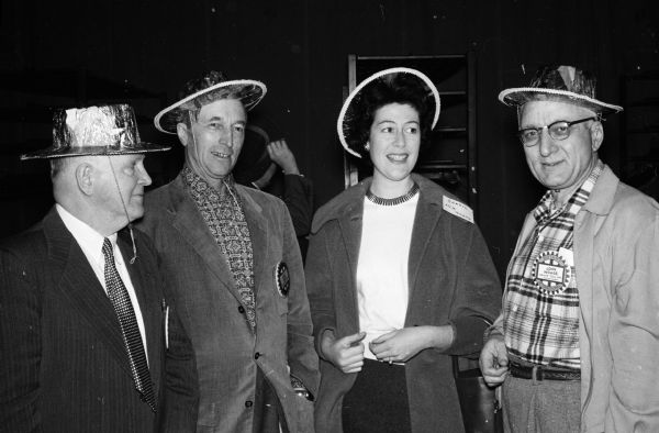 Madison Rotary Club members wore cowboy outfits for their "fiesta" to honor 150 foreign students attending the University of Wisconsin. Left to right are: Basil Peterson, chairman of the board for international service; Wilbur Renk, Rotary president; Lila Camargo Veirano, Rio de Janerio, Brazil, the only woman Rotary scholar at the university; and John Wrage, member of the international service board.