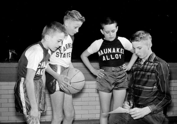 Dave Roberts, a freshman at Waunakee high school, gives some pointers to three players in the youth basketball league. The players are, left to right: Gary Adler, Marvin Zimmerman, and Tom Watts.
