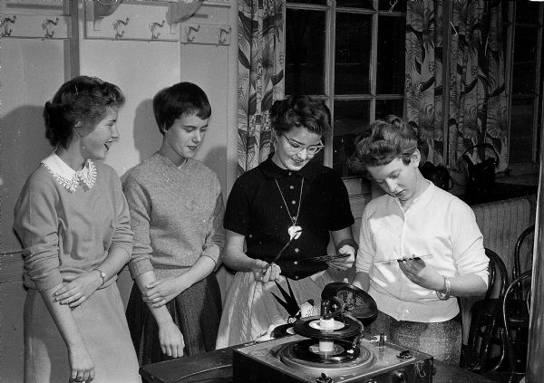 Activities at the Teen-Canteen at the YWCA, 122 State Street, are sponsored by the Junior High Y-Teen clubs in Madison. Four girls enjoying some records include, left to right: Peggy Moore, Sylvia Thompson, Sherri Pipkin, and Jane Tral.