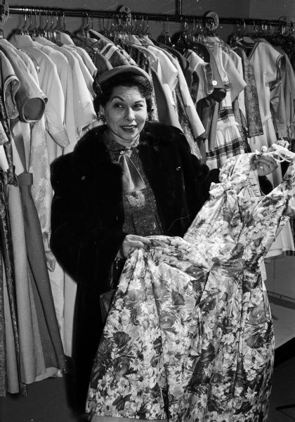 Rose Sussman, a former ballet dancer and teacher, shopping for a dress in a Madison store. The former Rose Goloff was born in the southern Ukraine section of Russia and was an eye witness to the atrocities of the Revolution in 1917. On four separate occasions she was lined up to be shot by Cossacks, but each time was somehow saved. She stated: "When you've seen people starve to death and be mowed down by bullets in the firing line, you have a special appreciation of the greatness of America." Rose is currently the wife of Democratic assemblyman from Milwaukee, Norman Sussman.