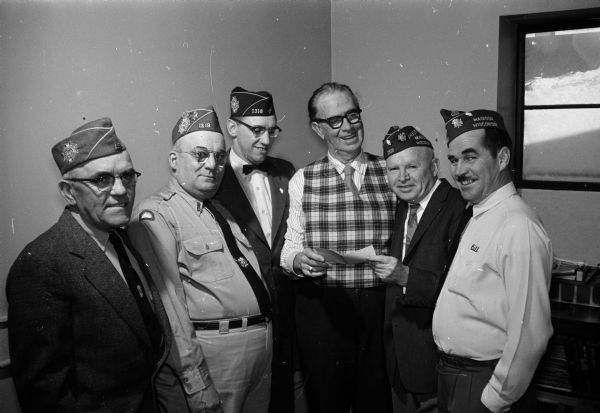 A group of men from the VFW Booster club presents a check to Roundy for "Roundy's Fun Fund." From left to right are: Bill Mathews, John Dobson, Earl Lyda, Roundy, John McGarvey, and Bill Rogers.