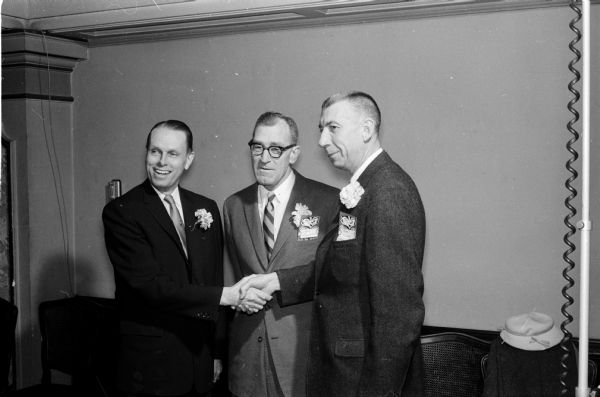 University of Wisconsin basketball coach Harold "Bud" Foster (right) is honored for his twenty-five years as head coach at the annual banquet. University president Conrad A. Elvehjem is at left and athletic director Ivan Williamson is in the center. Coach Foster is retiring.