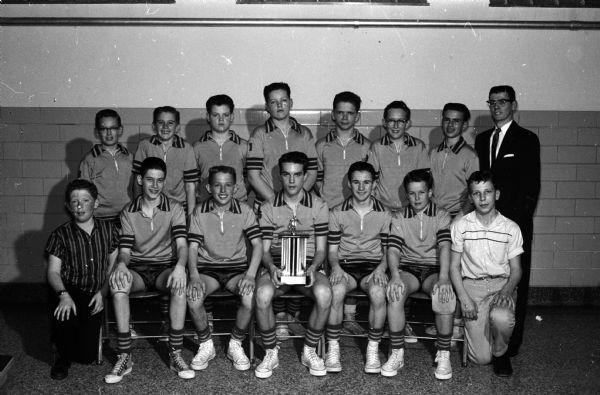 Group portrait of the Allis grade school basketball team that won the Suburban Elementary League championship. Their coach is Irv Kennedy, back row, right.
