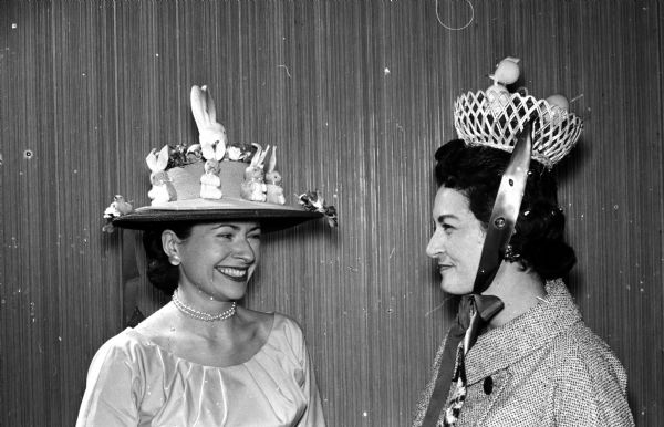 Original colorful hats of all types and designs appeared at the spring "Mad Hat" luncheon at the Blackhawk Country Club. Blanche Tallard, left, was awarded the prize for the "prettiest" hat. She designed a lavender hat with pink and blue bunnies to match her lavender frock. Shown with her is her neighbor, Mary Voss, who is wearing an Easter basket topped with a chicken and colored eggs.