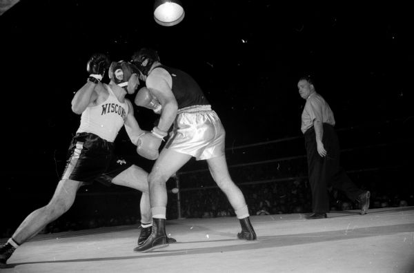 University of Wisconsin boxer Bill Urban (left) and Idaho State's Jerry Beebe slug it out chin-to-chin in their 178-pound match at the University of Wisconsin fieldhouse.