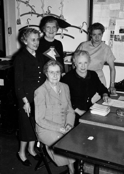 Group portrait of some of the chairmen of the Old Rectory shop, a resale shop. Seated, left to right, are: Annah Pierce, co-manager; Ethel Brubaker, manager; and standing, left to right, are: Burges Miles, finance; Julia Gerke, receiving; and Maxine Lighthall, treasurer.