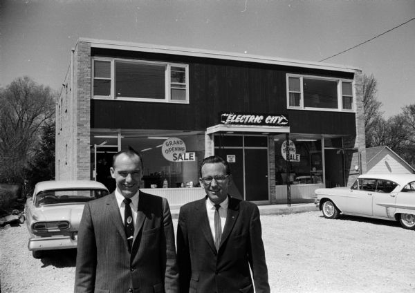 William H. Rietow, Jr. and Frank D. Hess stand in front of Electric City, a new appliance store at 4409 Monona Drive.