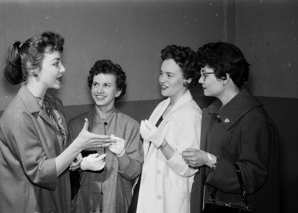A group of girls acts out a scene from a variety show put on by University of Wisconsin Dames Club units. The Lakeside Ladies enact "Wholesale Jeopardy", a satire on cocktail parties for executive's wives. The scene was from a variety show put on by the University of Wisconsin Dames Club units. The girls include, from left: Mrs. John Van Handel, Mrs. Eugene Melvin, Mrs. Gerald Elmer and Mary Anvoots.