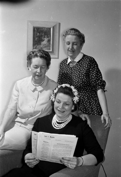Three members of a committee plan the annual spring banquet of the Catholic Women's club. Seated at center is Jean Riley, at left is Ann Hilsenhoff, and right, Mrs. William Robert.