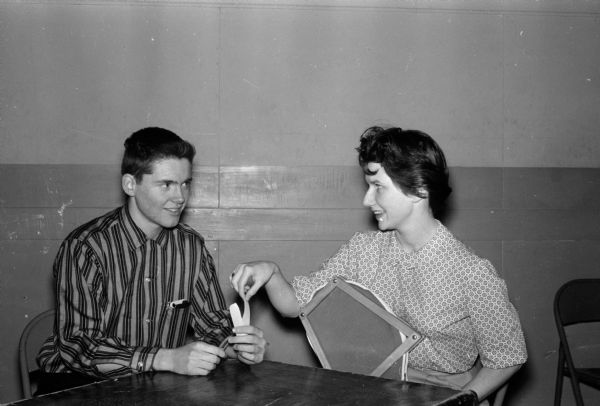 A series of photos of teenagers with the theme "What to do on a date." Mary Sue Miller and Dick O'Connor contemplate what movie to see in one of a series of photographs of teenagers themed, "What to Do on a Date."