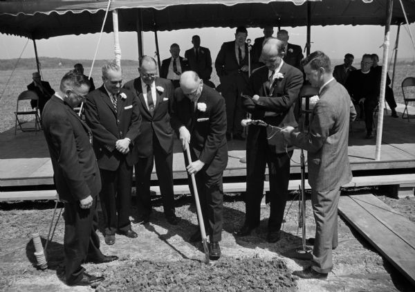A groundbreaking ceremony for a new building for CUNA Mutual Insurance Society takes place at the corner of Mineral Point Road and Rosa Road. Left to right are C.F. Eikel, Jr., managing director of the society; Paul Rogan, state insurance commissioner; William Knight, Jr., president of Sioux Falls, S. Dakota, CUNA; Harold Moses of New Orleans, president of CUNA Mutual; Madison Mayor Ivan A. Nestigen; and Richard Hagen, advertising director of CUNA Mutual. The insurance society was housed in the Filene House, 1617 Sherman Avenue, headquarters of the international credit union movement.