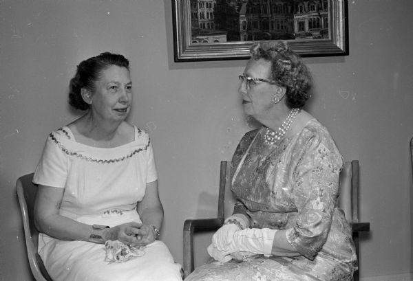 Two members of the decorating committee for the Madison Catholic Women's Cub's banquet, Helene McAndrews (right) and Mildred Morganson, talk while seated.