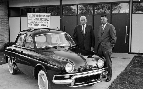 A car to be awarded to the winner of a limerick contest for the East Side Businessmen's Association (ESBMA) festival. Shown with the car are Leo Kronenberg, chairman of the contest committee, and Lloyd Foust, president of the ESBMA.