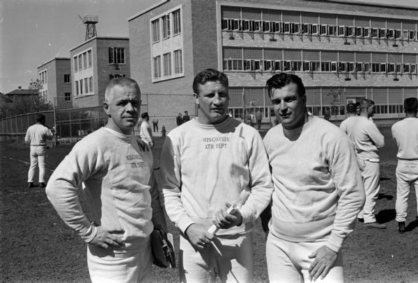 Group portrait of three coaches for the Alumni team for the annual University of Wisconsin Alumni-Varsity football game at Camp Randall Stadium. Left to right are: Bob Rennebohm, Ken Huxhold, and Don Kindt.