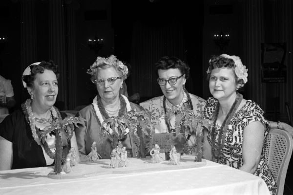 Four members of the Daughters of the Nile gather at a luncheon table decorated like a Hawaiian village at the group's spring luncheon. They include, from left: Mrs. William Reiter of McFarland, Miss Lillian Dean, Mrs. Olaf Severson of McFarland, and Mrs. Ruby McKee.