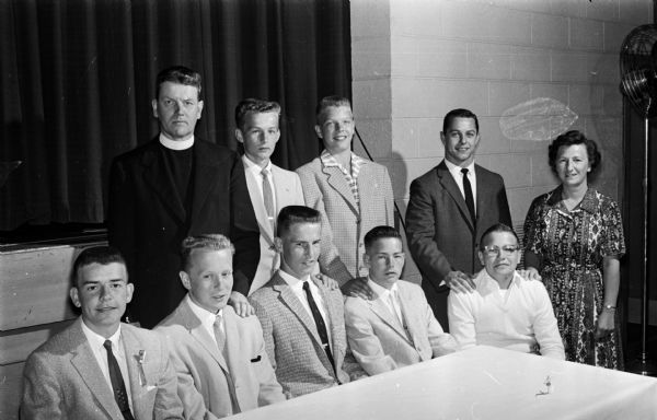 Group portrait of dignitaries at the annual Immaculate Heart of Mary athletic banquet. Seated, left to right, are: Dick Reinhold, Dan Ryan, Dennis Patterson, Paul Jaeger, and Jerry Sargent. Standing, left to right, are: Rev. Jerome Mersberger, Jim Ryan, Pat Gamble, Jim Innis, and Mariann (Johnnie) Zeier.