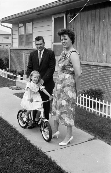 Donald and Audrey Forrer posing outdoors with their 7-year-old daughter Lydia, pictured riding a bicycle. The Red Cross provided the blood transfusions that helped save Lydia's life when she was an infant requiring heart surgery.