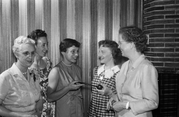 The Toastmistress Club celebrates its first year in Madison with a combination guest night and initiation of officers at the Cuba Club Supper Club. Mrs. Alfred Kennan accepts the president's gavel from Mrs. Patric Martin, president of the Beaver Dam Toastmistress Club. The incoming officers are (shown left to right) Miss Bertha Grunow, vice-president; Mrs. Stanley Nordstrom, club representative; Mrs. Kennan, president; Mrs. Martin; and Miss Edith Almquist, treasurer.