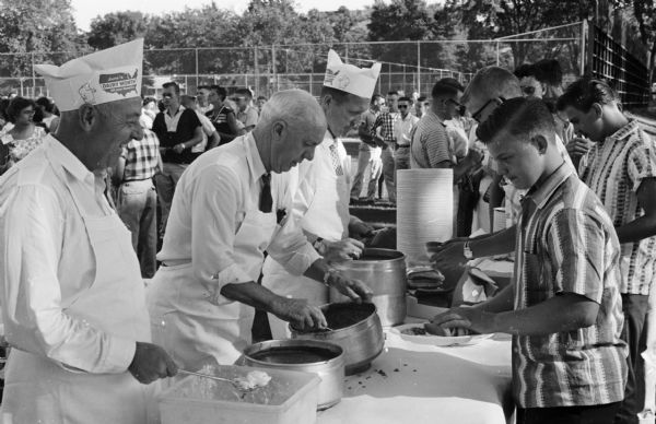Prominent Madison residents helped serve the 4-H group at the picnic on the University of Wisconsin inter-mural field. From left to right are: R.M. Henderson, assistant cashier at Bank of Madison; Duane Bowman, president of Bowman Farm Dairies and Robert Thayer, state department of agriculture.
