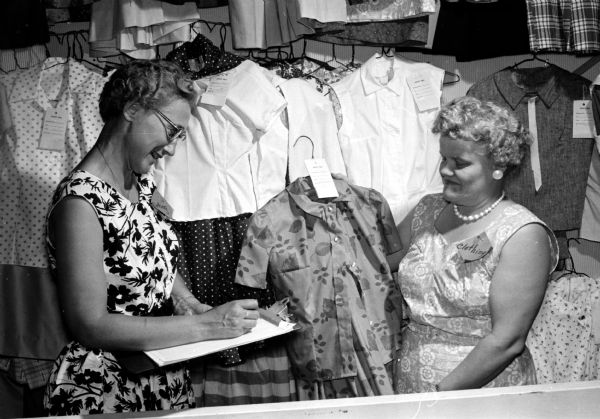 Mrs. Alvin Derr (left), Marshall, and Mrs. Edner Norland, Belleville, check in 2,098 clothing entries at the Dane County Junior Fair.