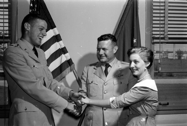 Lt. Donald B. Davidson, left, is congratulated for leading a record breaking bloodmobile event at the Truax Field Airbase. At center is Lt. Col. W.C. Croom, base executive commander and at right, Sage Stephens, whose life was saved by Red Cross blood.