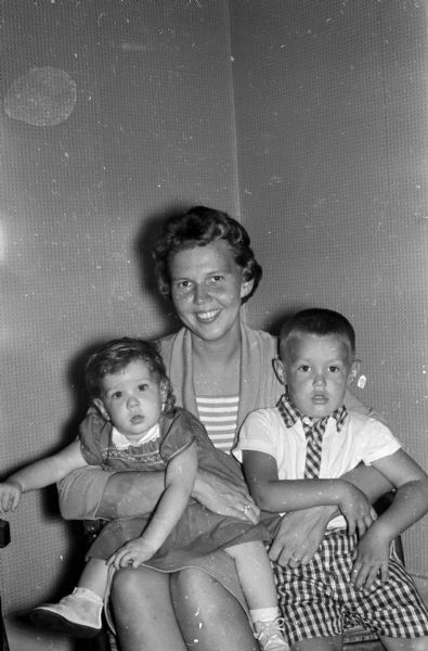 Group portrait of Mrs. June Padgham with her children, Julie and James. She is the general chairman of the annual fall style show sponsored by the Jaycettes, the Junior Chamber of Commerce auxiliary. James, age 3, will be one of the models the first night.