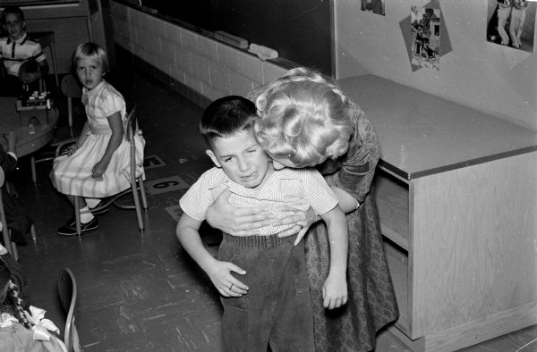 Florence Helmeid, Kindergarten teacher at Hoyt School comforts an unidentified boy during the first day of class.