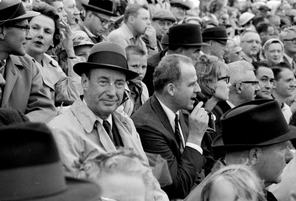 Adlai Stevenson and Governor Gaylord Nelson attend the Wisconsin-Stanford football game which turned into a very rainy event. They left the game at half time to escape the second half downpour.
