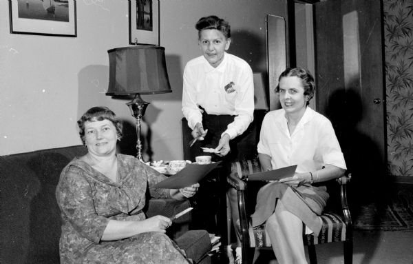 Three members of the Nakoma Welfare League complete preparations for the annual benefit card party. Left to right: Esther Poehling, Sarah Smith, and Ruth Benson.