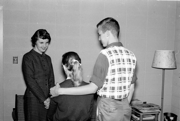 Mrs. Eileen Gattshall, a Family Service caseworker, greets two young people who have come to her for help. Family Service is one of 29 Red Feather agencies in the United Givers Fund.