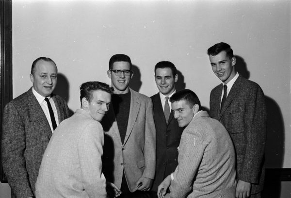 Madison East High School football coach Herbert (Butch) Mueller poses with his five all-city players prior to the school's annual dinner. To the right of the coach, left to right, are: Mike Kipp, Larry Biddick, Terry Thor, Doug Hyslop, and Chuck Zink.