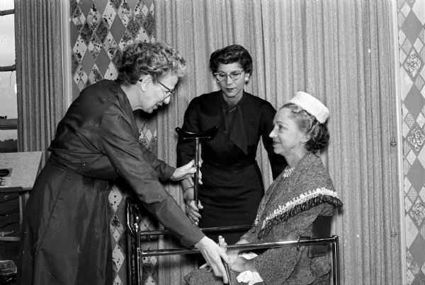 Miss Agnes Griffith, Mrs. Doris Rubin, and Mrs. Ruth Towell look at some of the nursing displays at the annual meeting of the Madison Visiting Nurse Service at Maple Bluff Country Club.