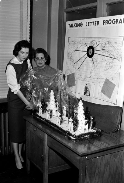 Mrs. Barbara Featherstone and Mrs. Edith Norman unveil a Christmas centerpiece for the annual Red Cross Christmas Talking Letter project. The centerpiece was made by Edith's son-in-law, Lorne Winchester, of Phoenix, Arizona. The project lets families of service men serving overseas record a three-minute talking letter for their family member.