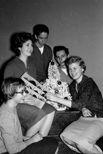 Teenagers Joan Wilke (left), Ruth Rauschenberger, Rick Smith, Bob Dicke, and Betsy Paddock complete preparations for the annual young people's party of the Nakoma Welfare League.